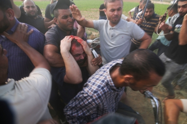 하마스 대원들이 머리에 피를 흘리고 있는 남성을 강제로 끌고 가고 있다. ⓒ연합뉴스