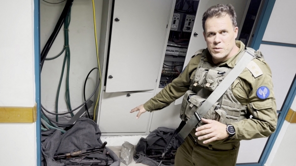 이스라엘군 중령이 15일(현지시간) 가자지구 최대 의료기관인 알시파 병원 내 MRI 센터에서 발견된 무기를 가리키고 있다. 이날 이스라엘군은 하마스가 병원을 군사작전에 사용한다며 MCRI 센터에서 발견된 수류탄과 총기류 등의 무기 사진을 공개했지만, 하마스는 이스라엘이 증거를 조작했다며 반박했다. [출처=로이터/연합]
