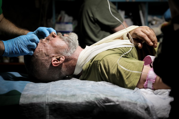 우크라이나 전선 바흐무트에서 한 우크라이나 군인이 의무대로부터 치료를 받고 있는 모습 [사진 = 연합뉴스]