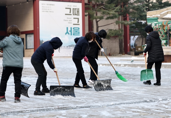 전국 곳곳에 밤 사이 눈이 내린 20일 오전 서울역사박물관 앞에서 관계자들이 제설작업을 하고 있다. [출처=연합]
