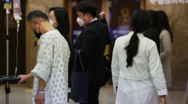 27일 오후 서울의 한 대학병원에서 환자 뒤로 의료진이 지나가고 있다. [연합뉴스]