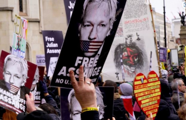 A large crowd of people holding signs with supportive slogans of Julian Assange. Julian Assange had plenty of support outside the Royal Courts of Justice on The Strand when his hearing took place earlier this year.(ABC News)
